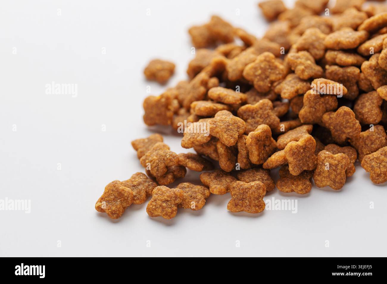 Trockenfuttergranulat für Hunde auf weißem Hintergrund. Stockfoto