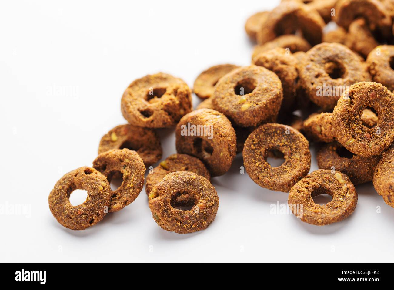 Trockenfuttergranulat in Form eines Rings für Hunde auf weißem Hintergrund. Stockfoto