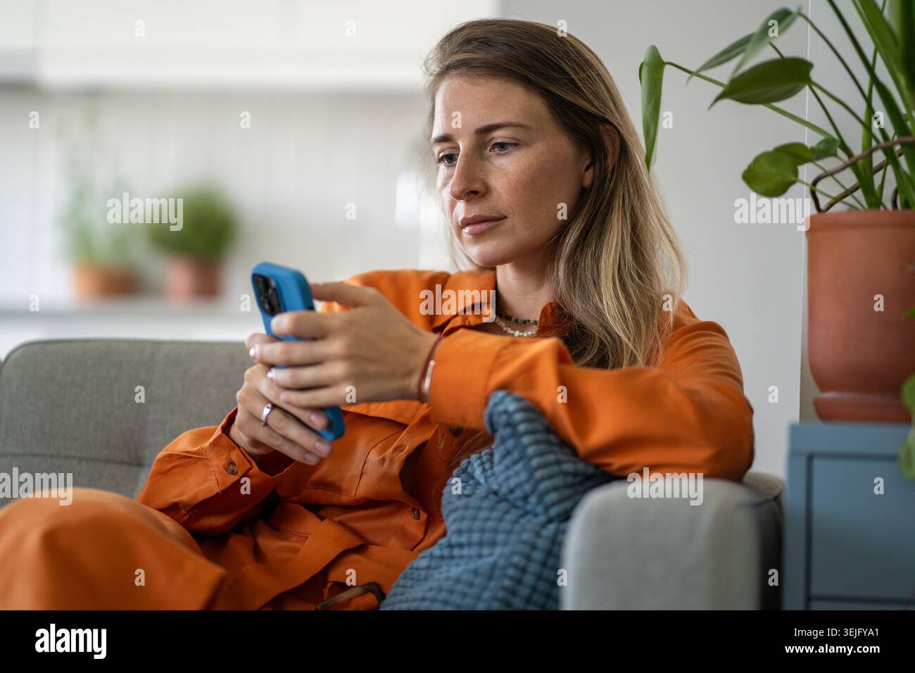 Eine Frau mittleren Alters konzentriert sich sehr auf das Surfen von Inhalten mit ruhigem, bewusstem Ausdruck Stockfoto