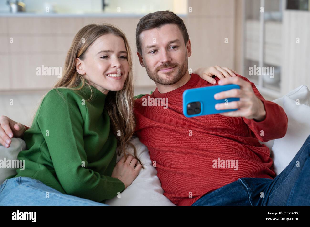 Glückliche Liebespaare machen Selfies für soziale Medien zu Hause auf dem Handy und fangen Momente ein. Stockfoto