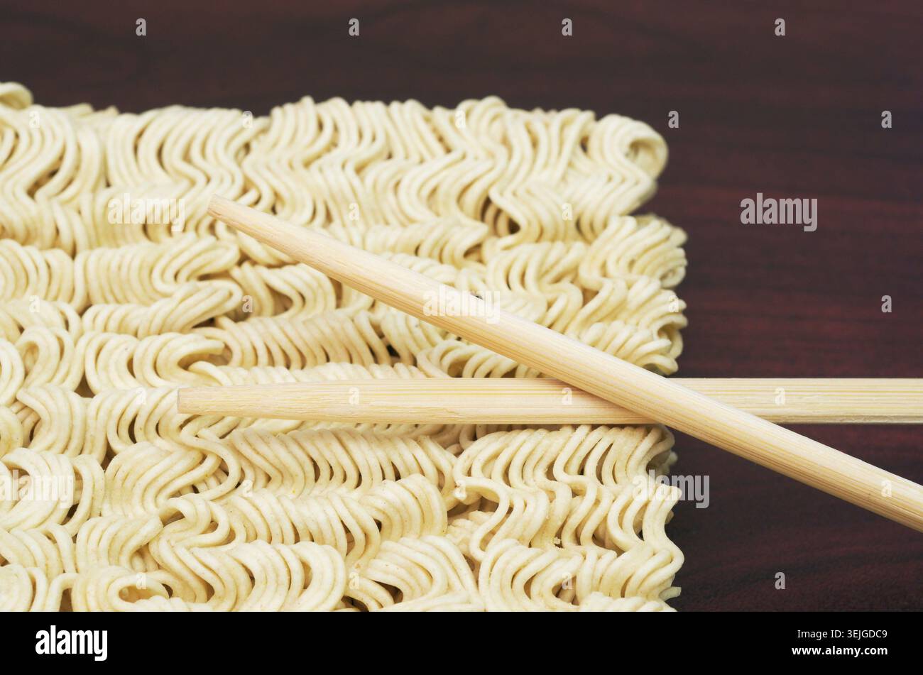 Rohe Instant-Nudeln und hölzerne Essstäbchen Stockfoto