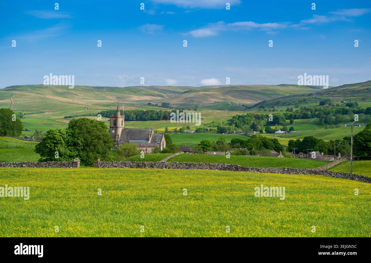 St. Margarets Church, Hawes, im Frühsommer, mit Wildblumenwiese vor Staggs fiel hinter. North Yorkshire, Großbritannien. Stockfoto