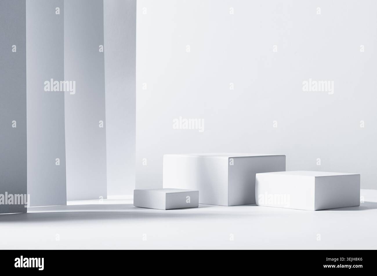 Minimalistisches abstraktes Design für Präsentation und Produktpräsentation – weiße quadratische Podeste im Sonnenlicht mit Schatten in weißen Geometrien Stockfoto