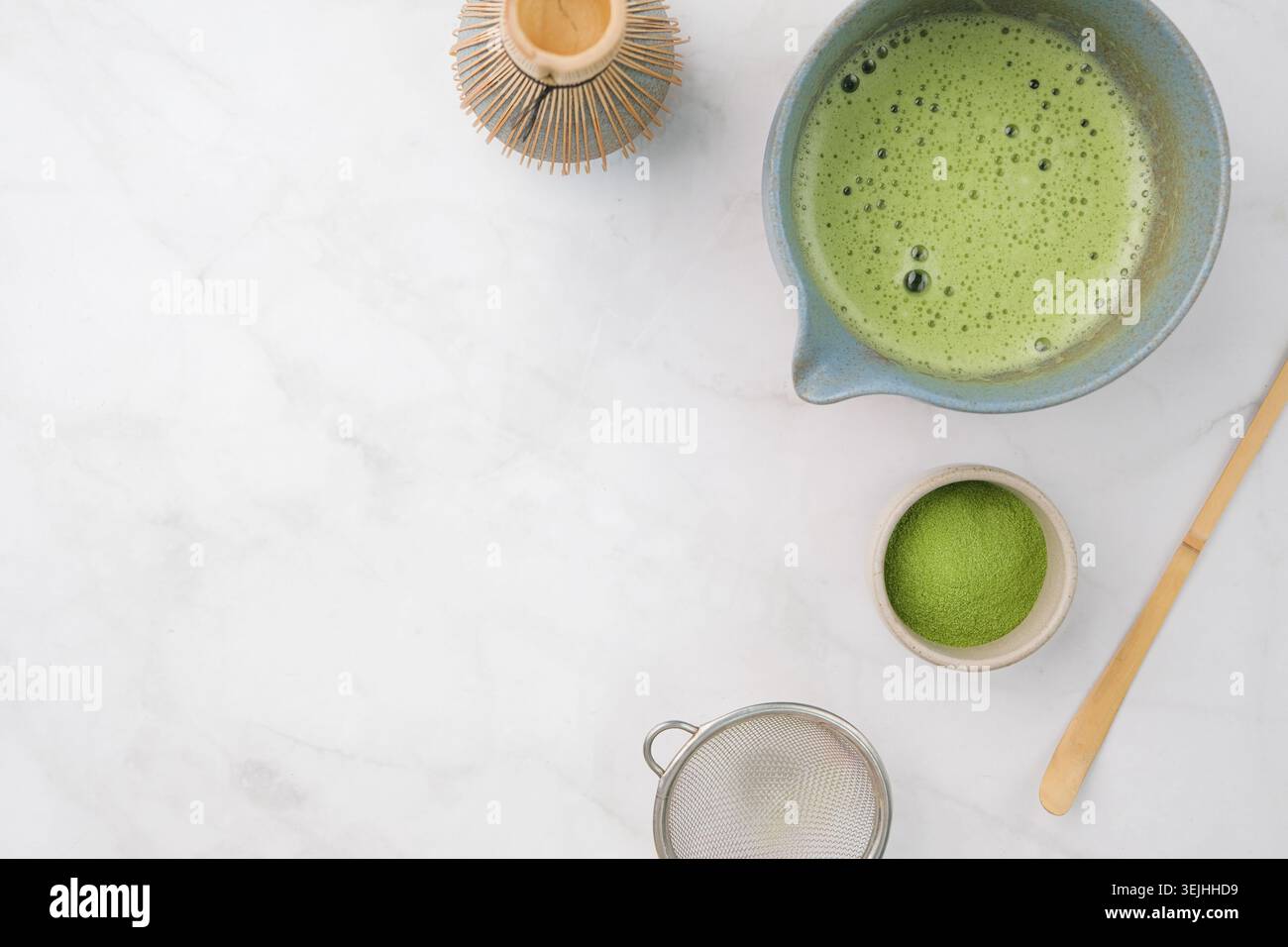 Traditionelles Matcha-Set, Bambus-Schneebesen und Getränk auf Marmorhintergrund in der Küche Stockfoto