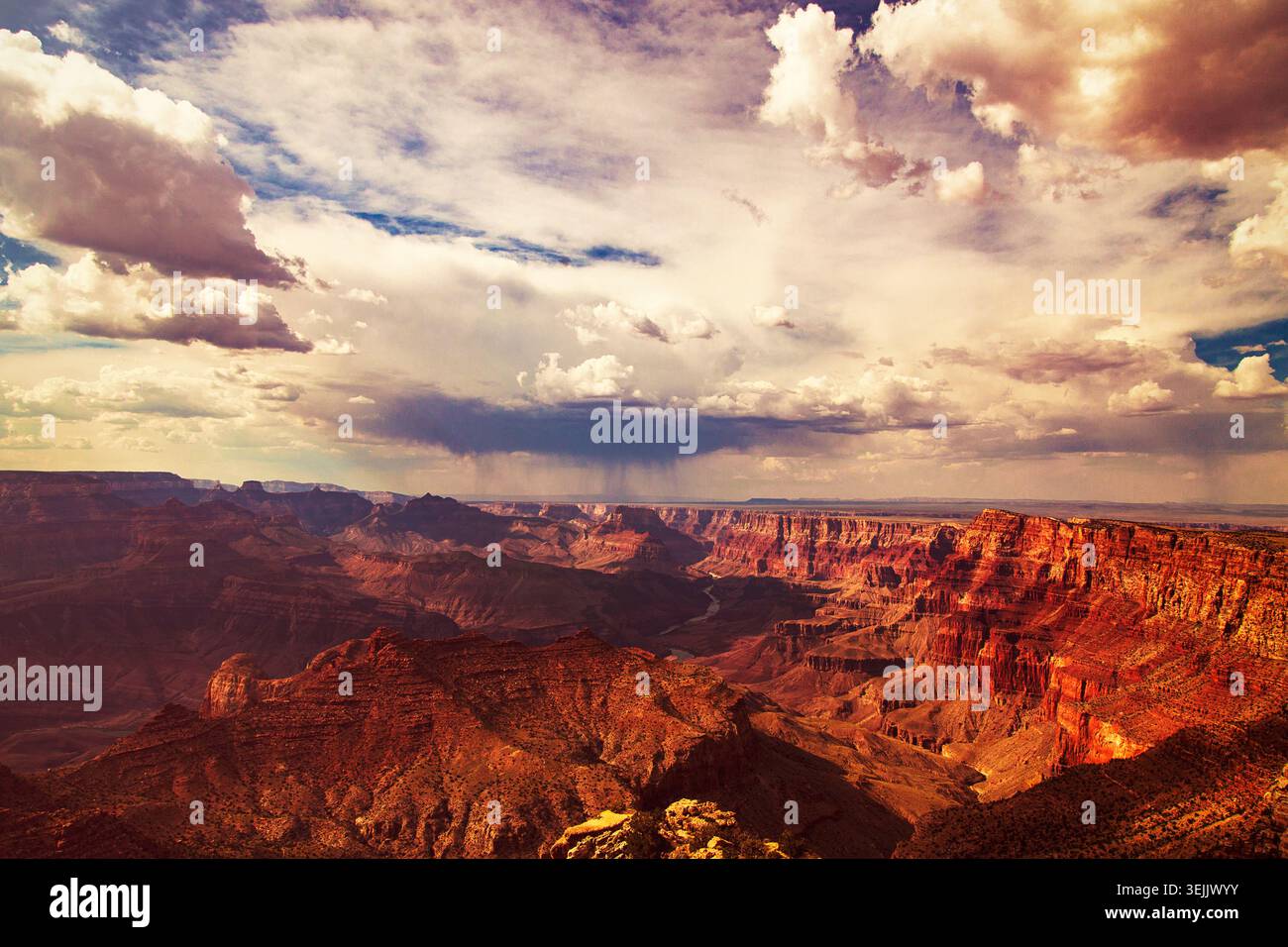 Großer Canyon mit Sturmwolken, die Regen über die riesigen Felsformationen und den colorado River gießen Stockfoto