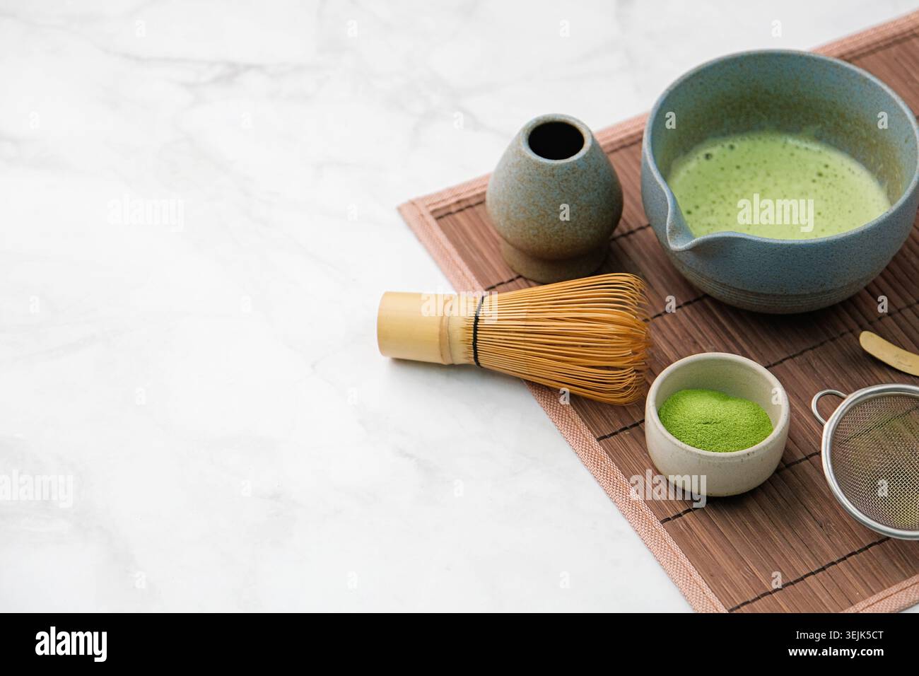Traditionelles Matcha-Set, Bambusquirl und Getränk auf Bambusmatte in der Küche Stockfoto
