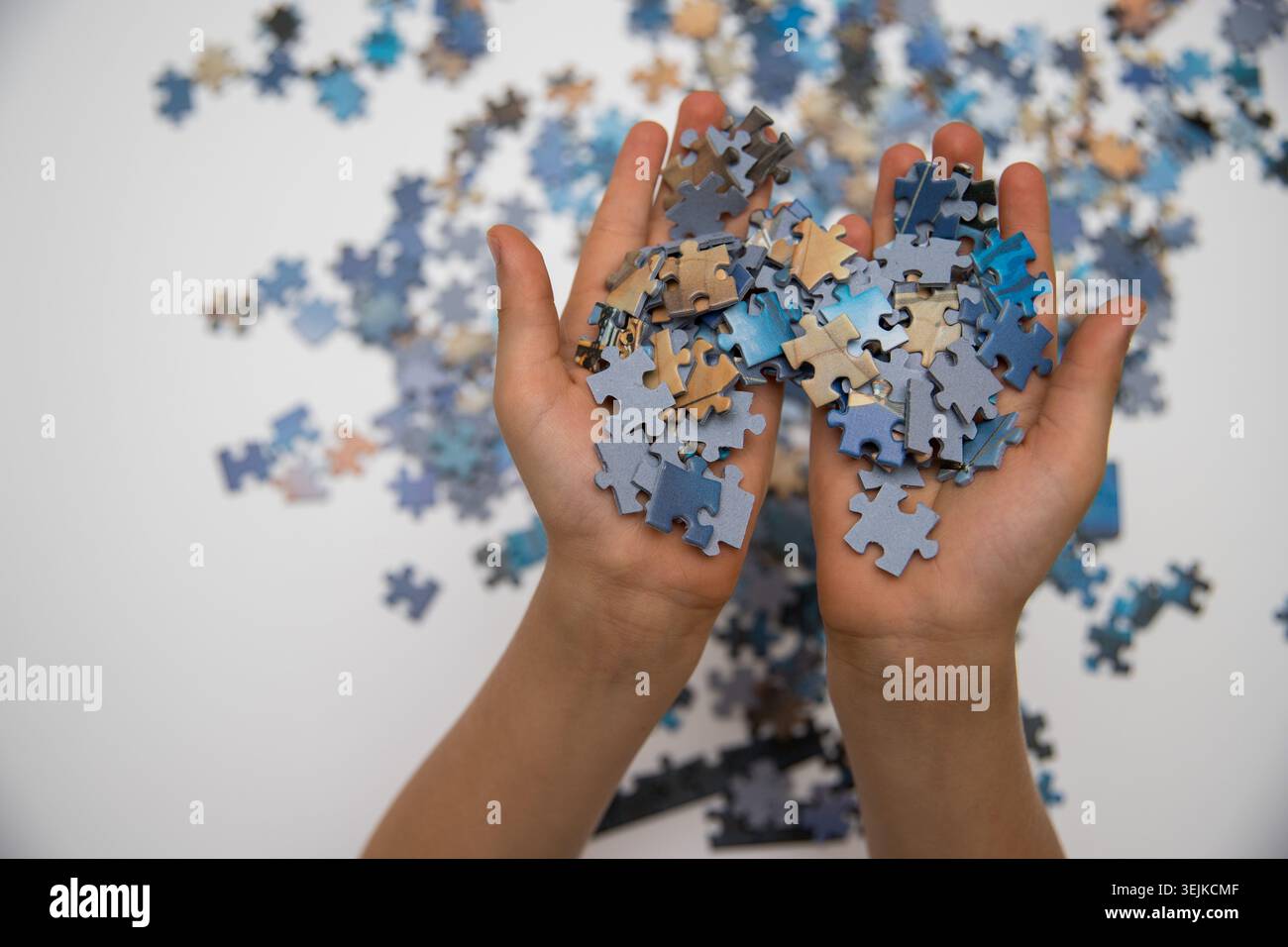 Das Kind, das Puzzleteile zusammensetzt, als Lern- und Problemlösungskonzept Stockfoto