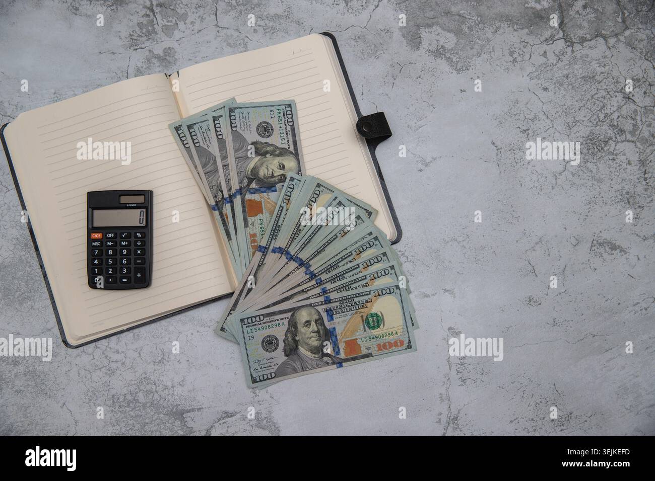 Persönliches Finanz-, Budgetierungs- und Konsumentenkonzept mit Bargeld und Taschenrechner auf grauem Hintergrund Stockfoto