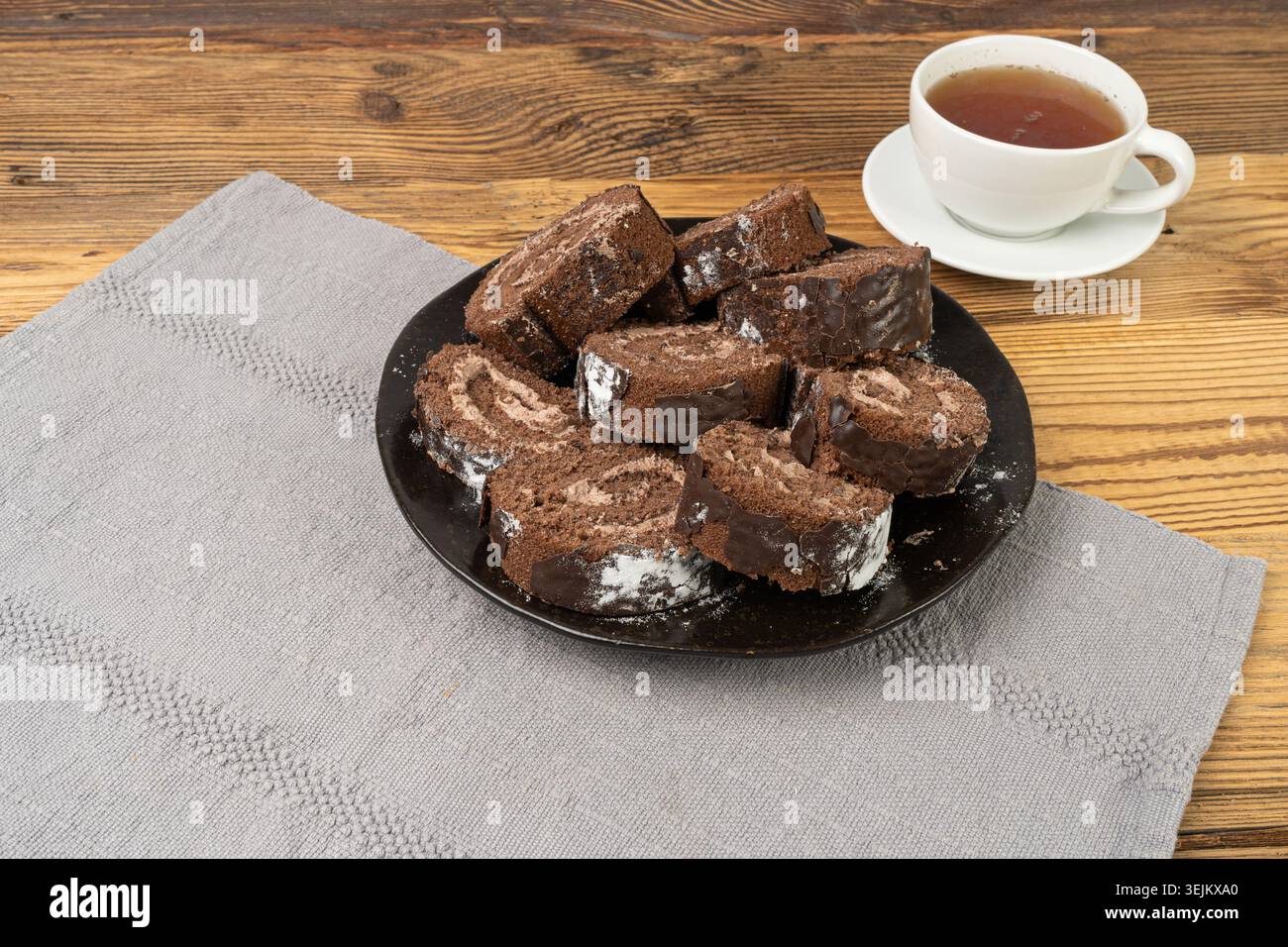 Schokolade Schweizer Rolle, Runde Schwammkuchen, geschnittener gerollter Vanillekeks mit Kakaocreme Füllung, Schweizer Dessert, Blockkuchen auf rustikalem hölzernem Hintergrund Stockfoto
