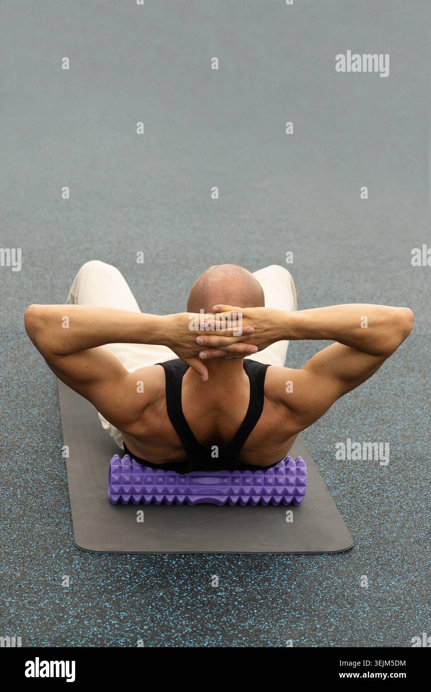 Auslösepunkt für Rückenmassage mit Schaumstoffrolle. Myofasziale Freisetzung. Stockfoto