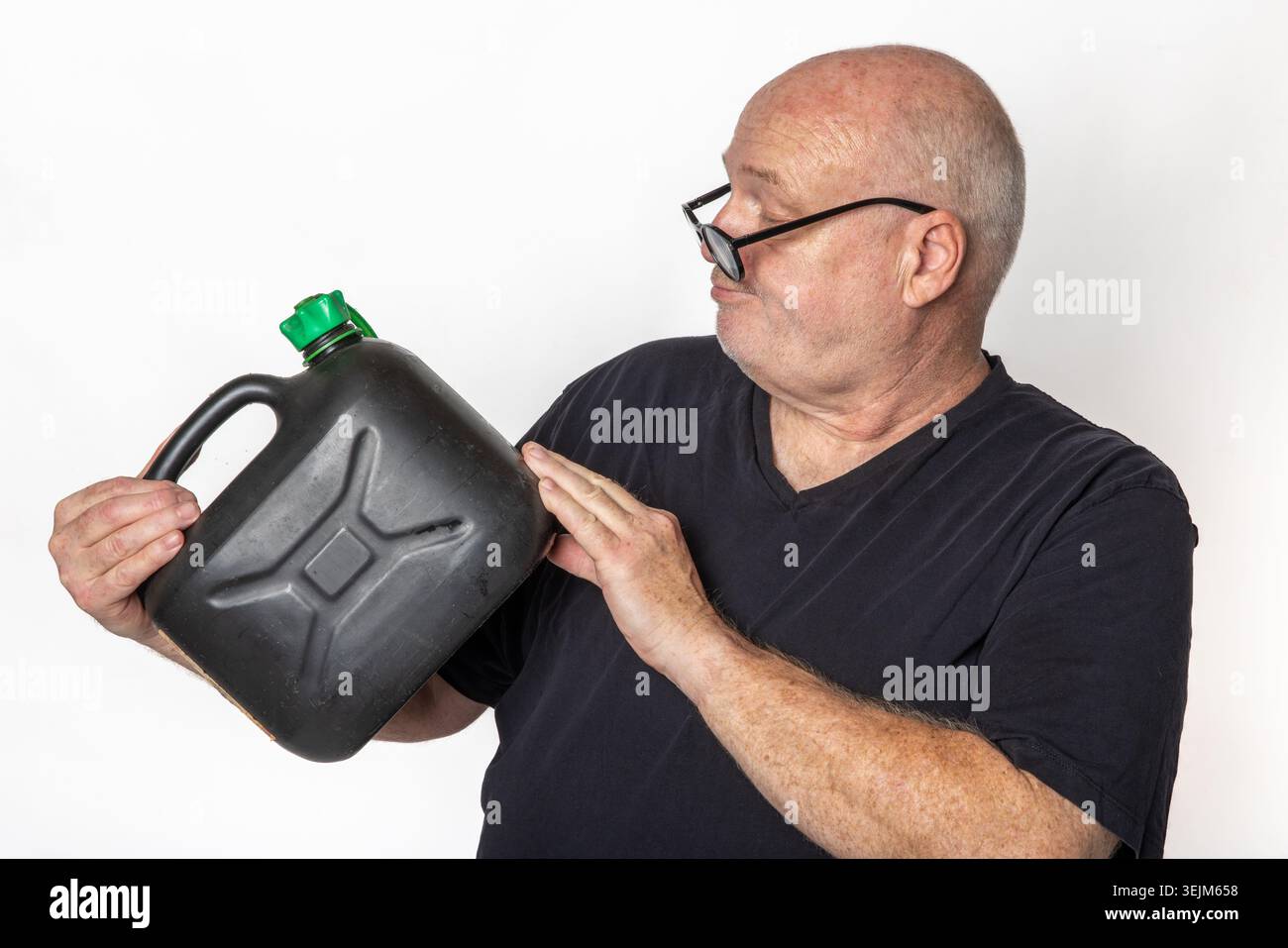 Porträt eines älteren Mannes mit Brille, der sich mit leerem Gaskanister, hohen Kraftstoffpreisen und Energiekrisenkonzept befasst. Stockfoto