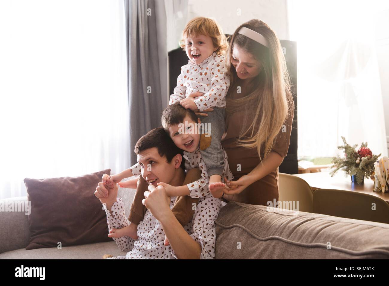 Familie hat Spaß, Zeit zu Hause zusammen zu verbringen. Mom, Dad und zwei Sohn spielen, umarmen und Spaß zu Hause haben. Christm Stockfoto