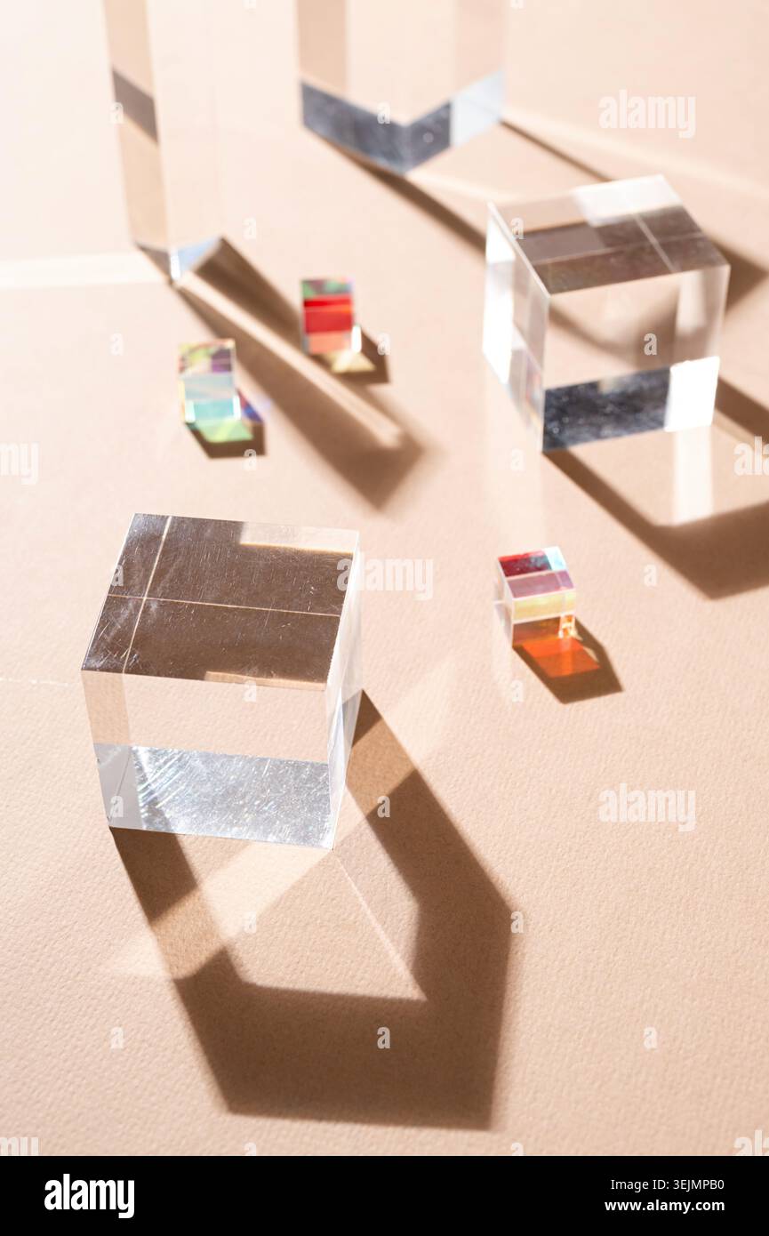 Glasprismen reflektieren das Licht und bilden wunderschöne Schatten auf beigefarbenem Hintergrund Stockfoto