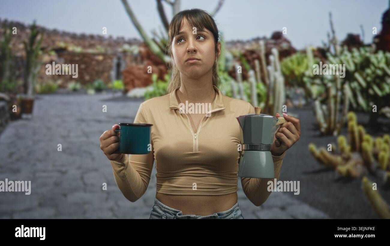 Frau mit blauem Becher und Mokakopf auf einer gepflasterten Straße, grimmiert am Getränk; ekelhafte Zögern am Morgen. Stockfoto
