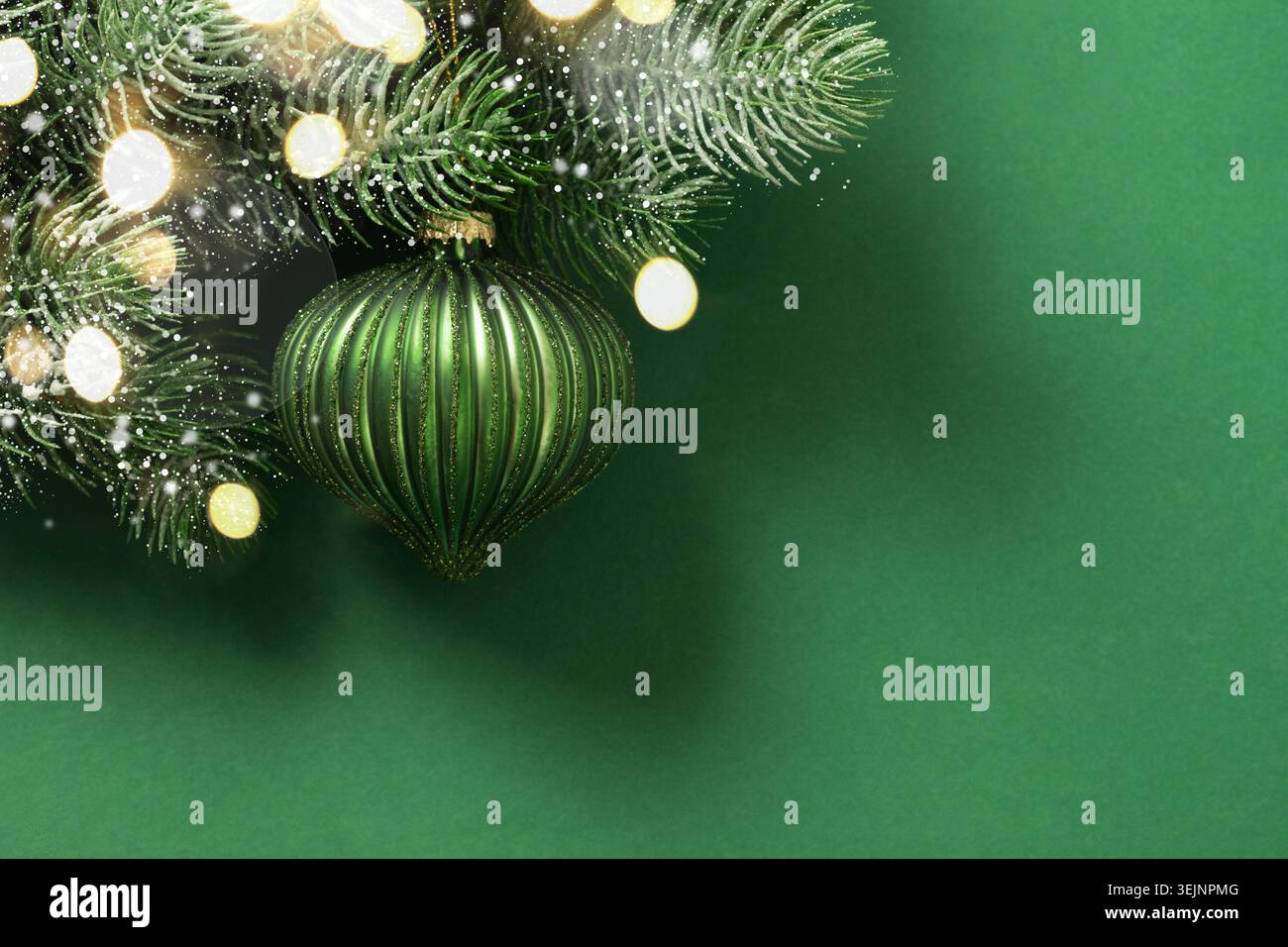 Rote Weihnachtskugel auf verschneiten Tannenzweigen auf Beige. Weihnachtskarte. Stockfoto