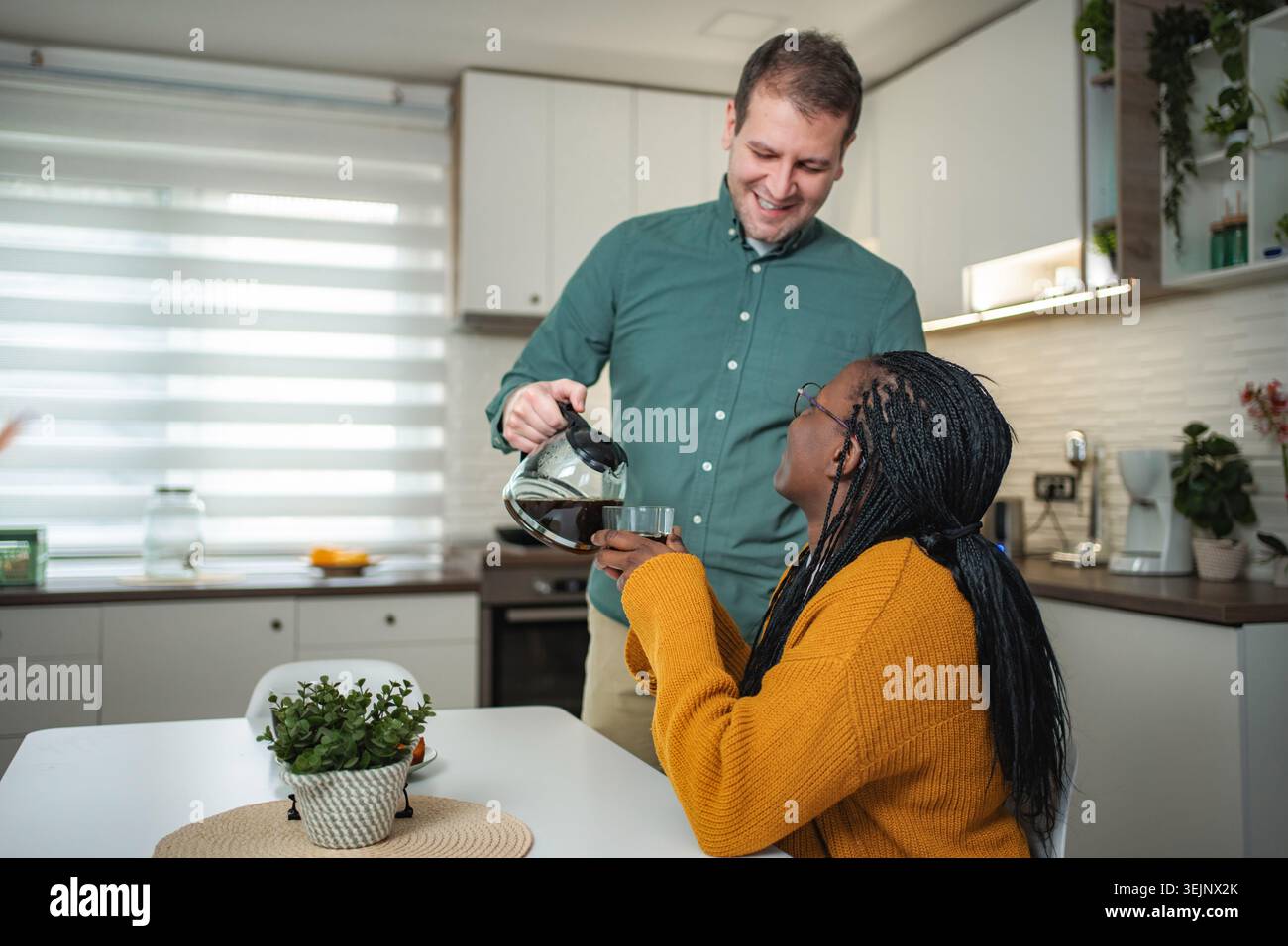 Glückliches Paar genießt Morgenkaffee zusammen in der Küche Stockfoto