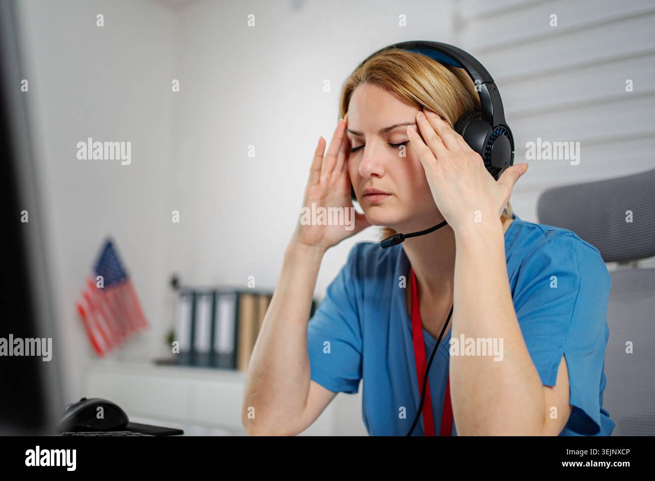 Gestresste Frau im Headset mit Migräne am Arbeitsplatz Stockfoto
