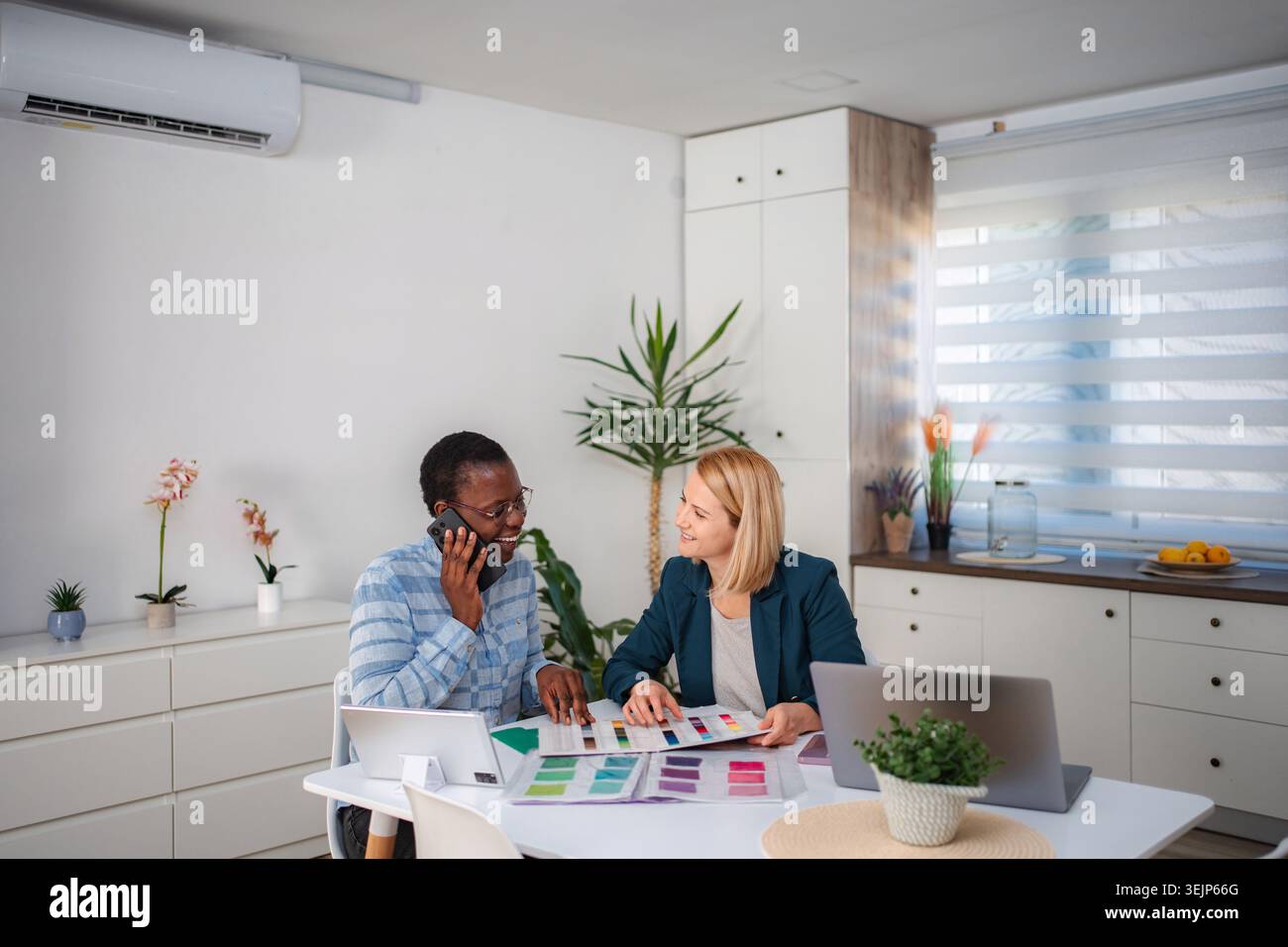 Innenarchitekten diskutieren Farbmuster und arbeiten an Projekten zusammen Stockfoto