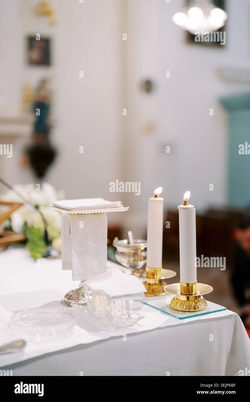 Ruhiges religiöses Ambiente mit Kerzen und farbenfrohen Glasmalereien Stockfoto