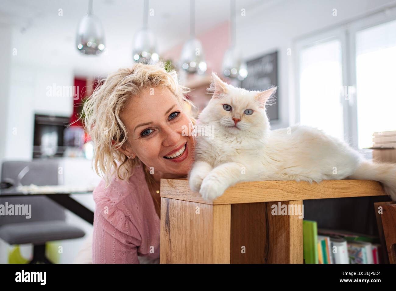 Frau lächelt mit Hauskatze Stockfoto