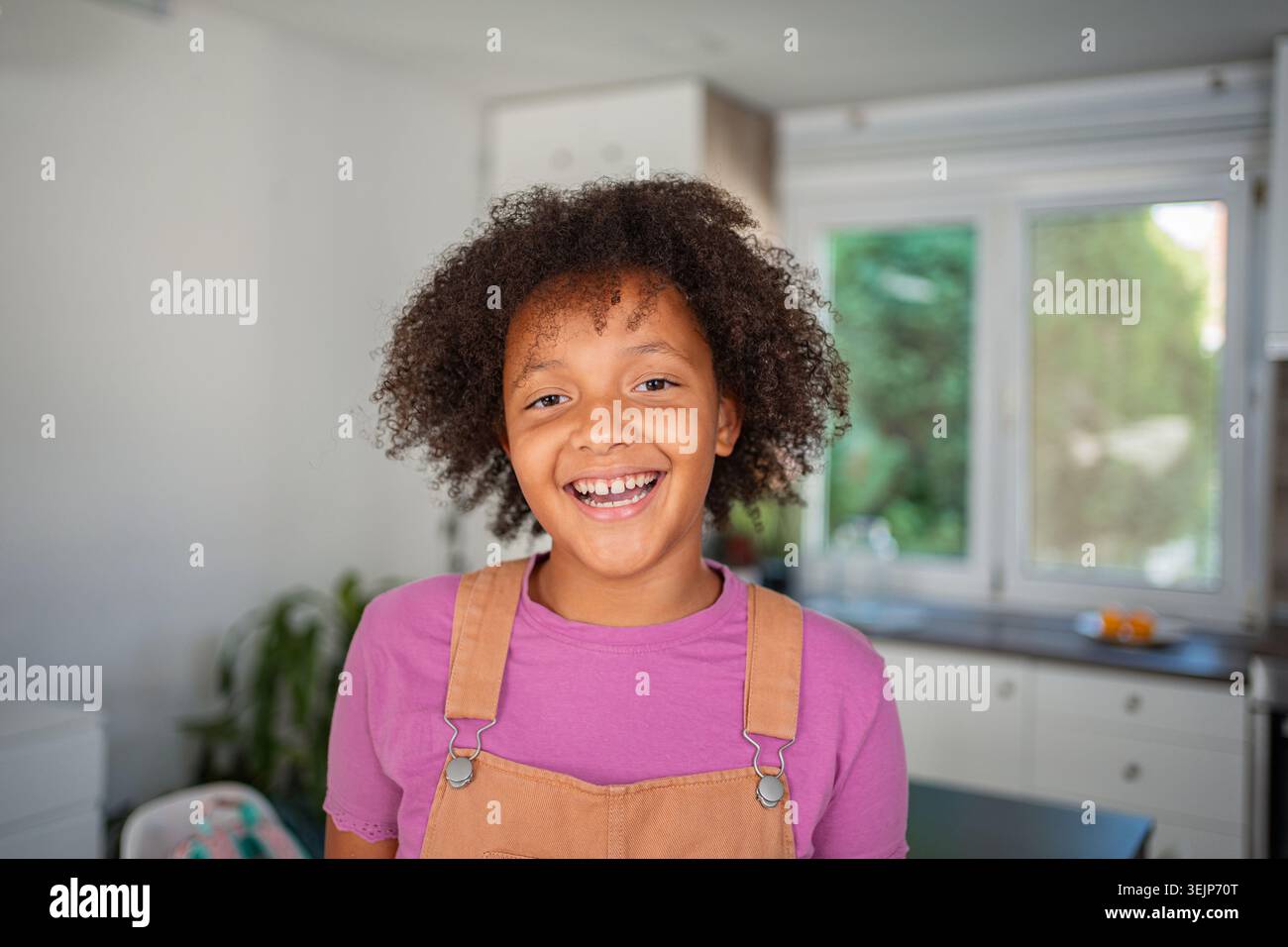 Glückliches afroamerikanisches Mädchen, das zu Hause lächelt Stockfoto