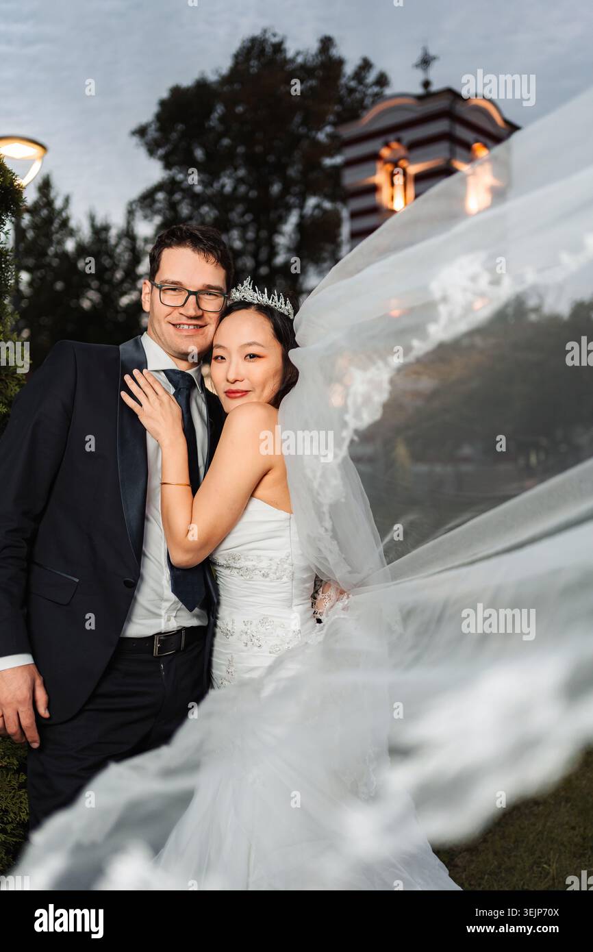 Braut und Bräutigam posieren bei ihrer Hochzeit im Freien Stockfoto