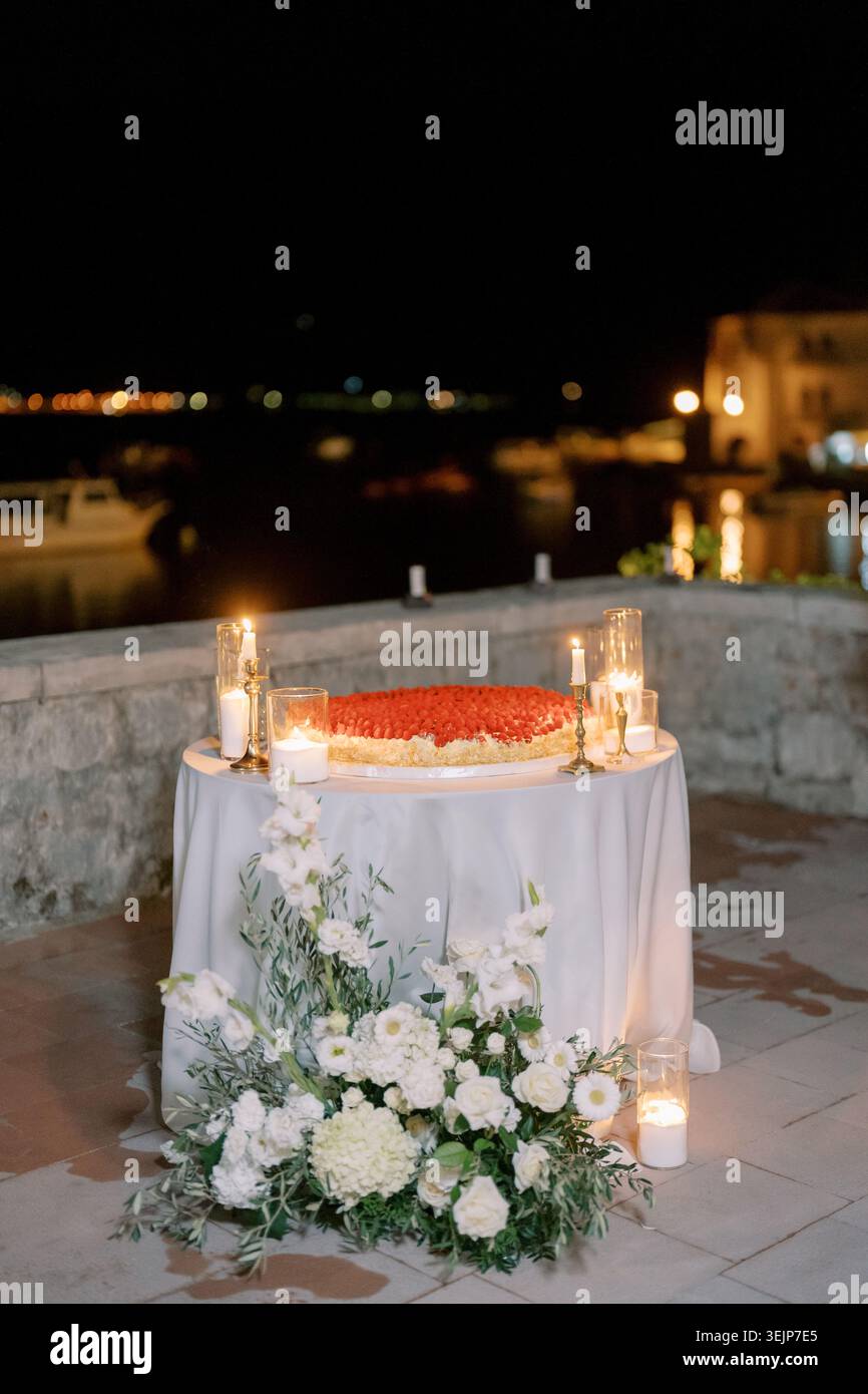 Romantische Feier am Meer. Elegante Gelübdezeremonie auf der Steinterrasse der Küste mit Blumen und Kerzen Stockfoto