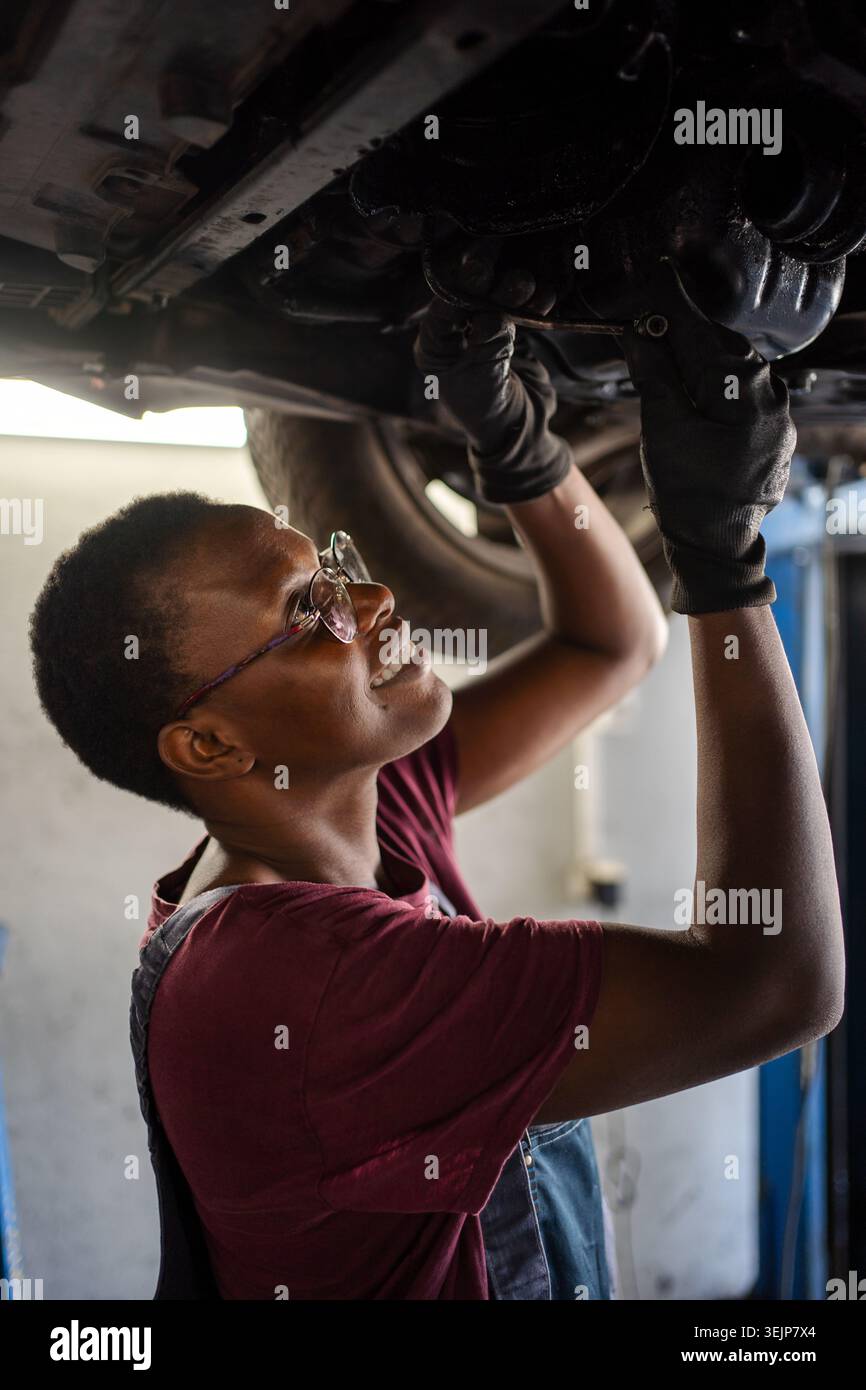 Junge Mechanikerin repariert Auto in einer Garage Stockfoto