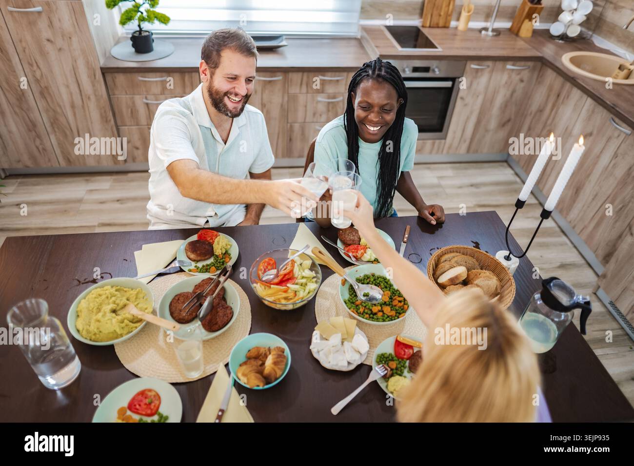 Freunde versammeln sich, um zu Hause mit einer fröhlichen Mahlzeit zu feiern Stockfoto