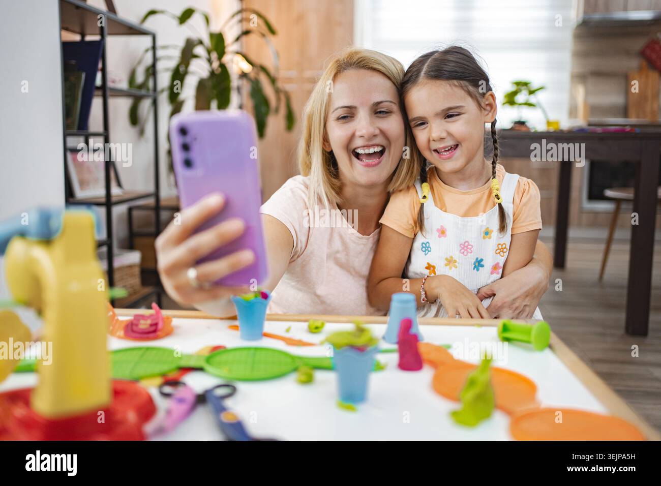 Mutter und Tochter genießen einen spielerischen Moment während sie ein Selfie machen Stockfoto