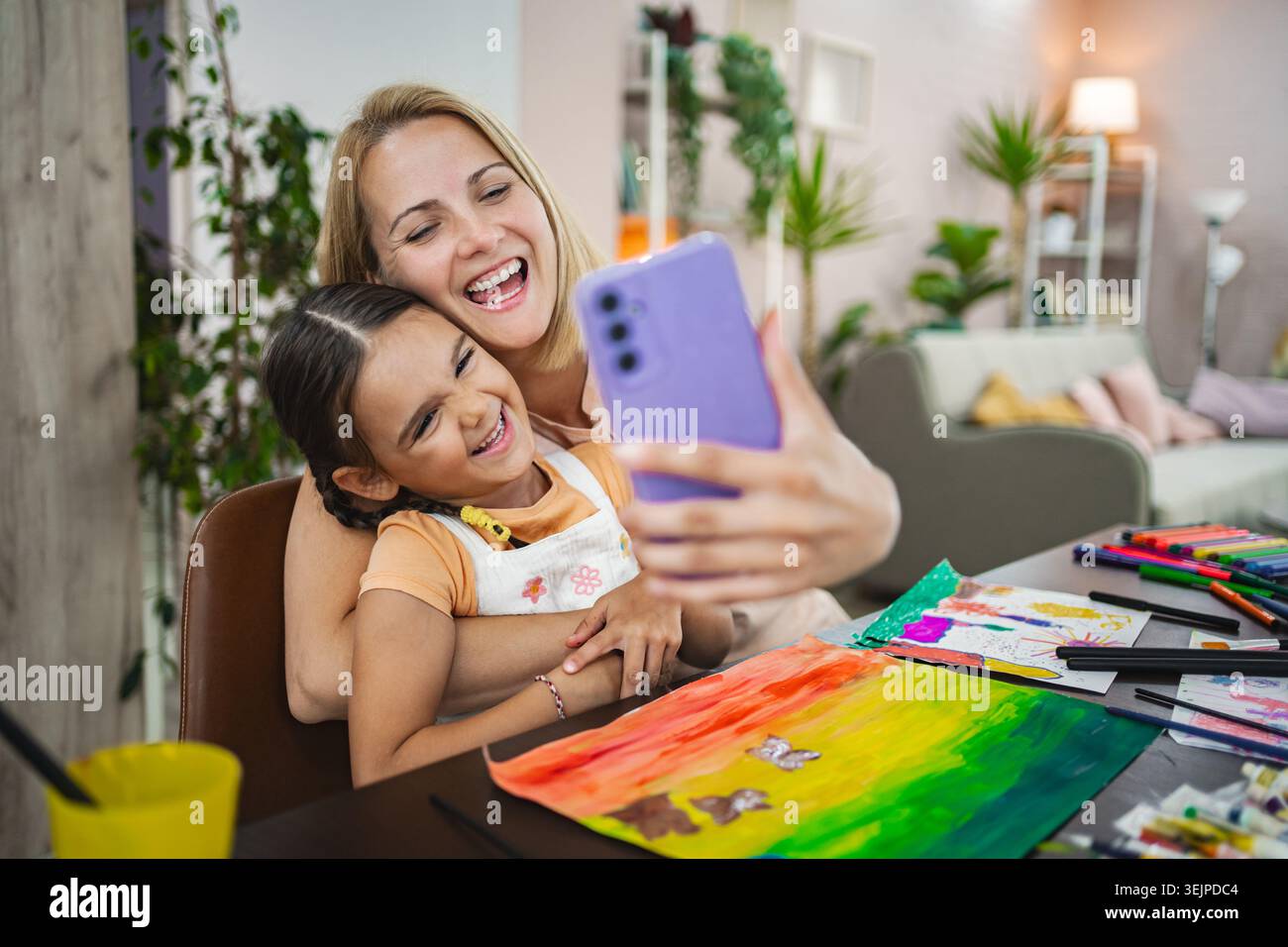 Mutter und Tochter genießen einen freudigen Moment, während sie gemeinsam ein Selfie machen Stockfoto