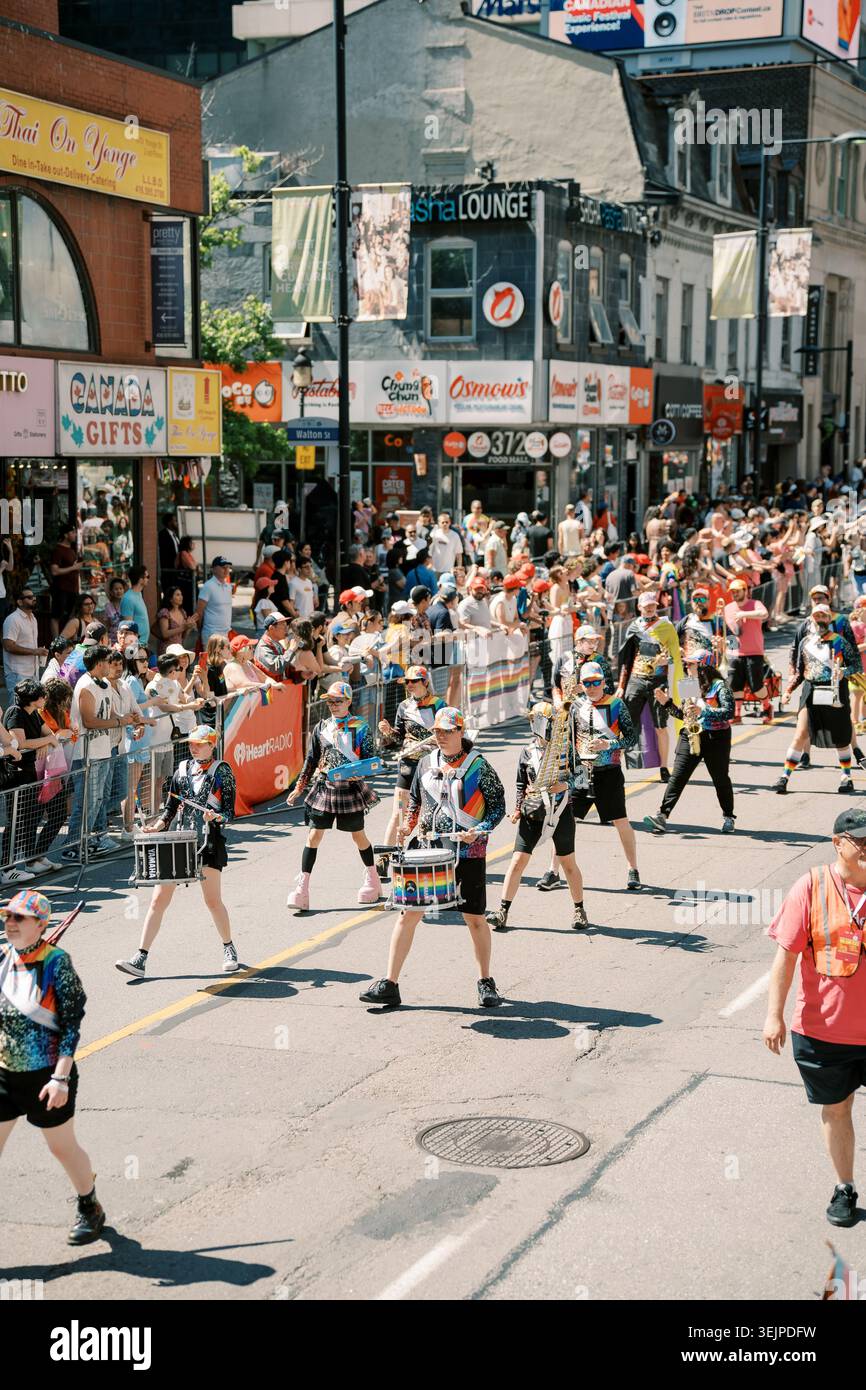 Toronto, Kanada - 29. Juni 2025: Überfüllte stadtmärsche schlängeln sich an lokalen Ladenfronten vorbei Stockfoto