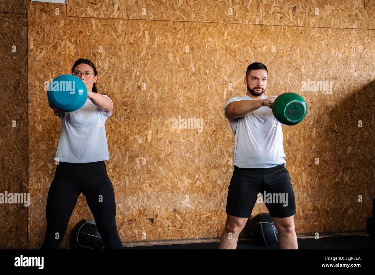 Menschen, die in einem Fitnessstudio mit Kettlebells trainieren Stockfoto