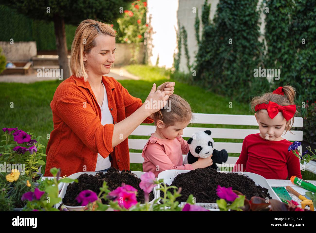 Lustige Gartenarbeit mit Kindern in einem sonnigen Hinterhof Stockfoto