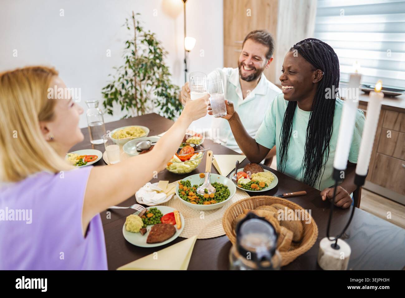 Freunde genießen ein helles Abendessen zu Hause Stockfoto