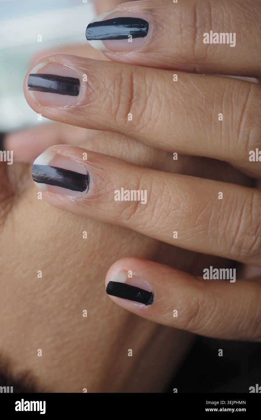 Nailart-Design mit Schwarz-weiß-Farben an den Händen Stockfoto