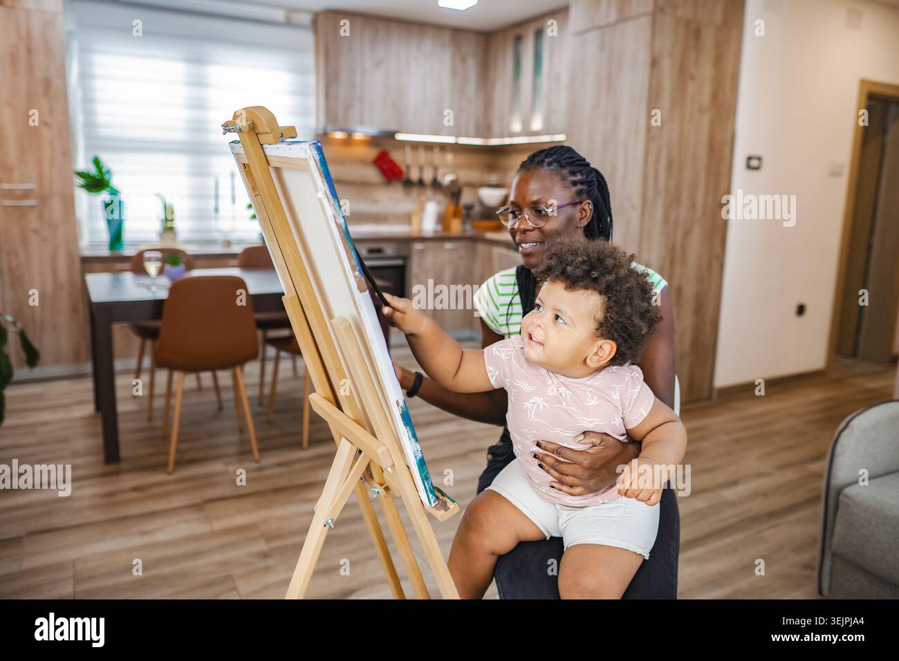 Mutter und Kind binden sich beim Malen drinnen Stockfoto