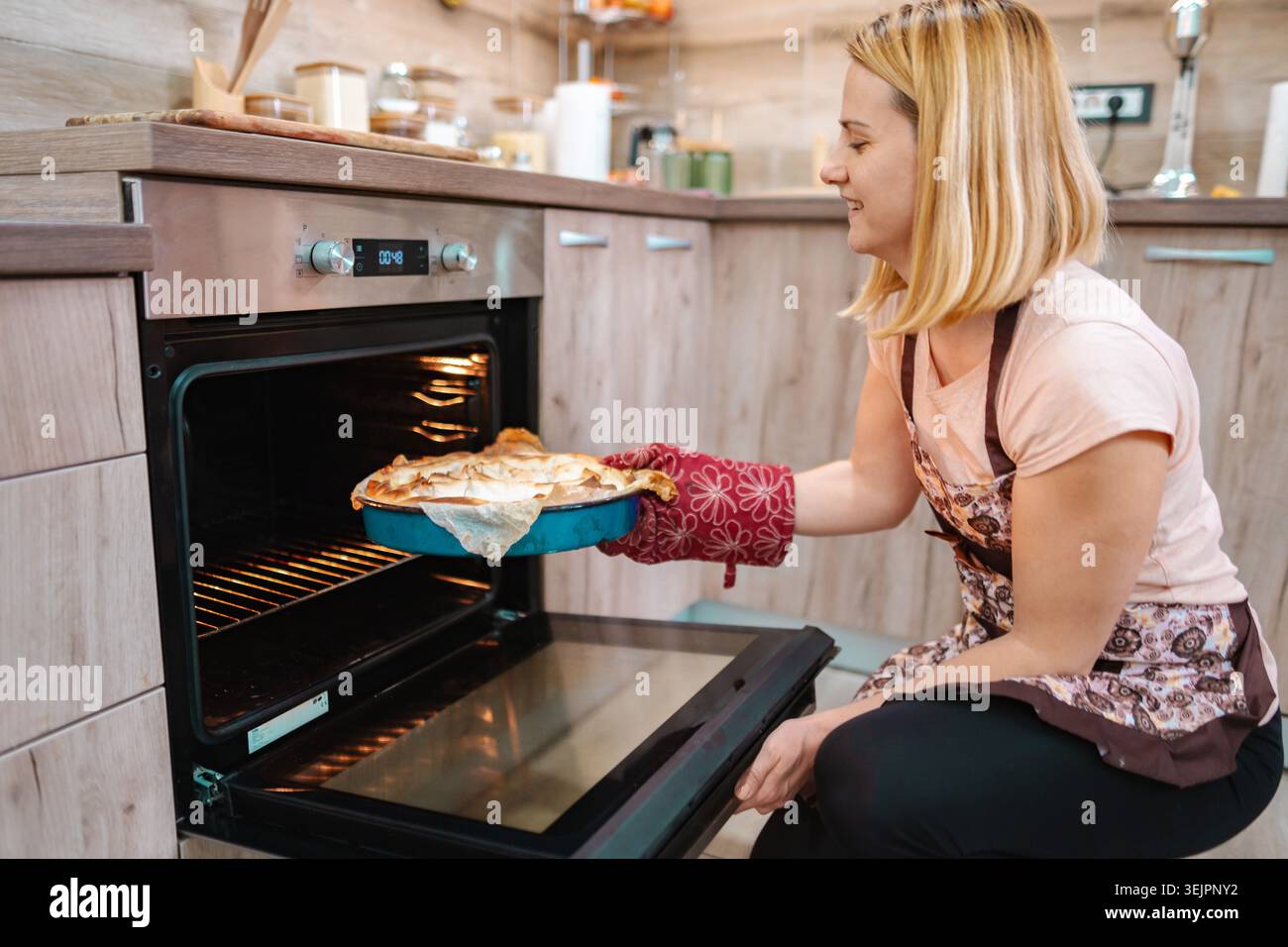 Backen in einer gemütlichen Küche mit einem fröhlichen Koch Stockfoto