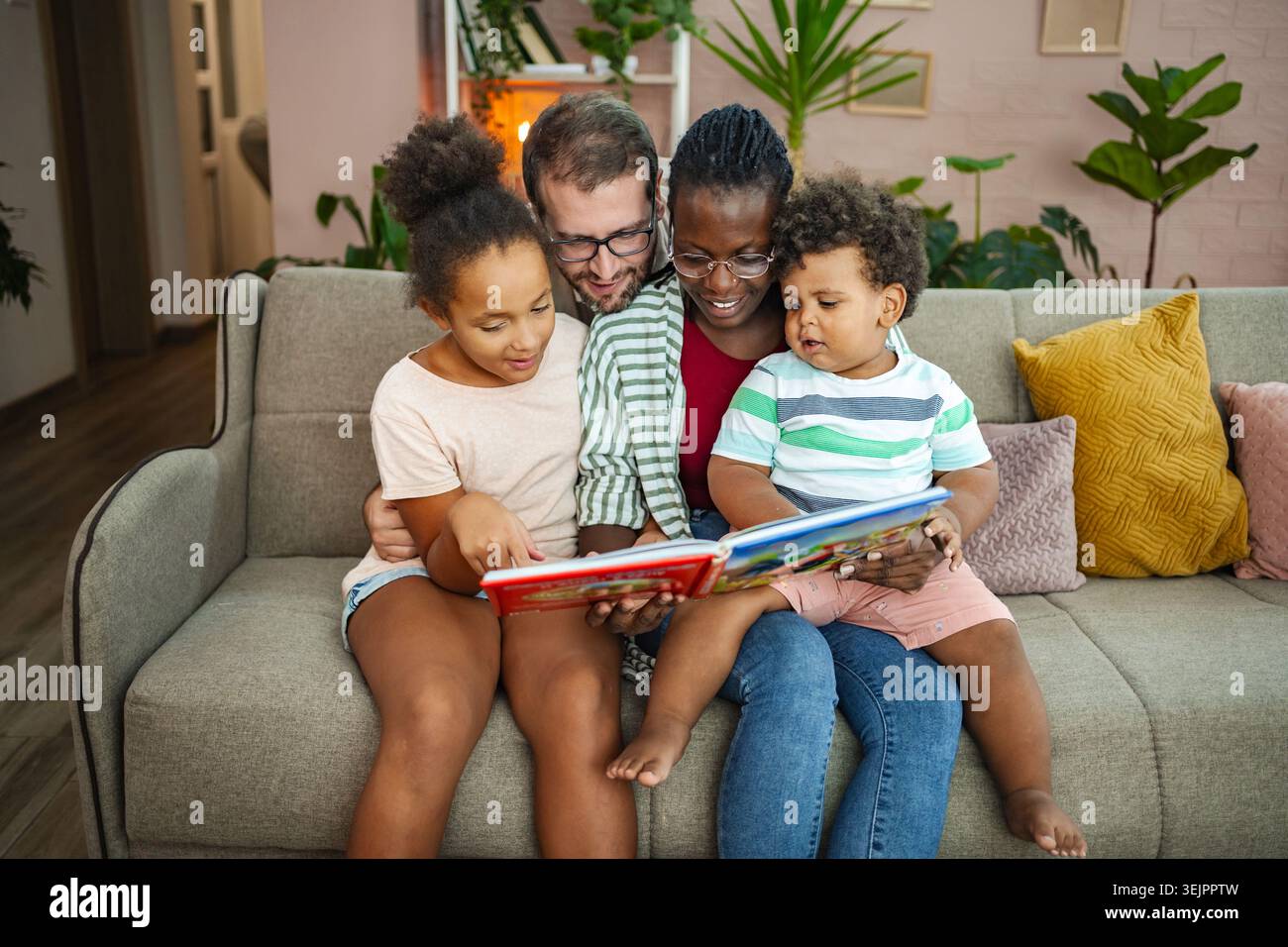 Familie genießt Geschichten in einem gemütlichen Wohnzimmer zusammen Stockfoto