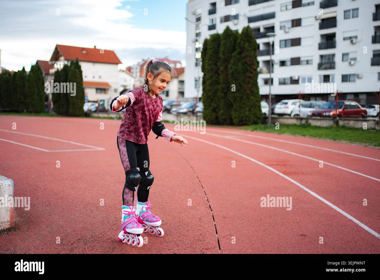 Mädchen lernen Inlineskaten auf der Outdoor-Bahn Stockfoto