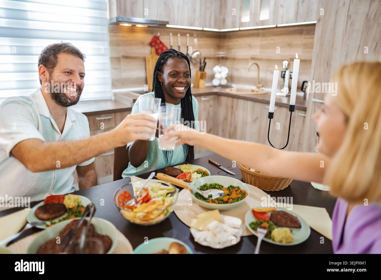 Freunde essen glücklich in einer gemütlichen Küche Stockfoto
