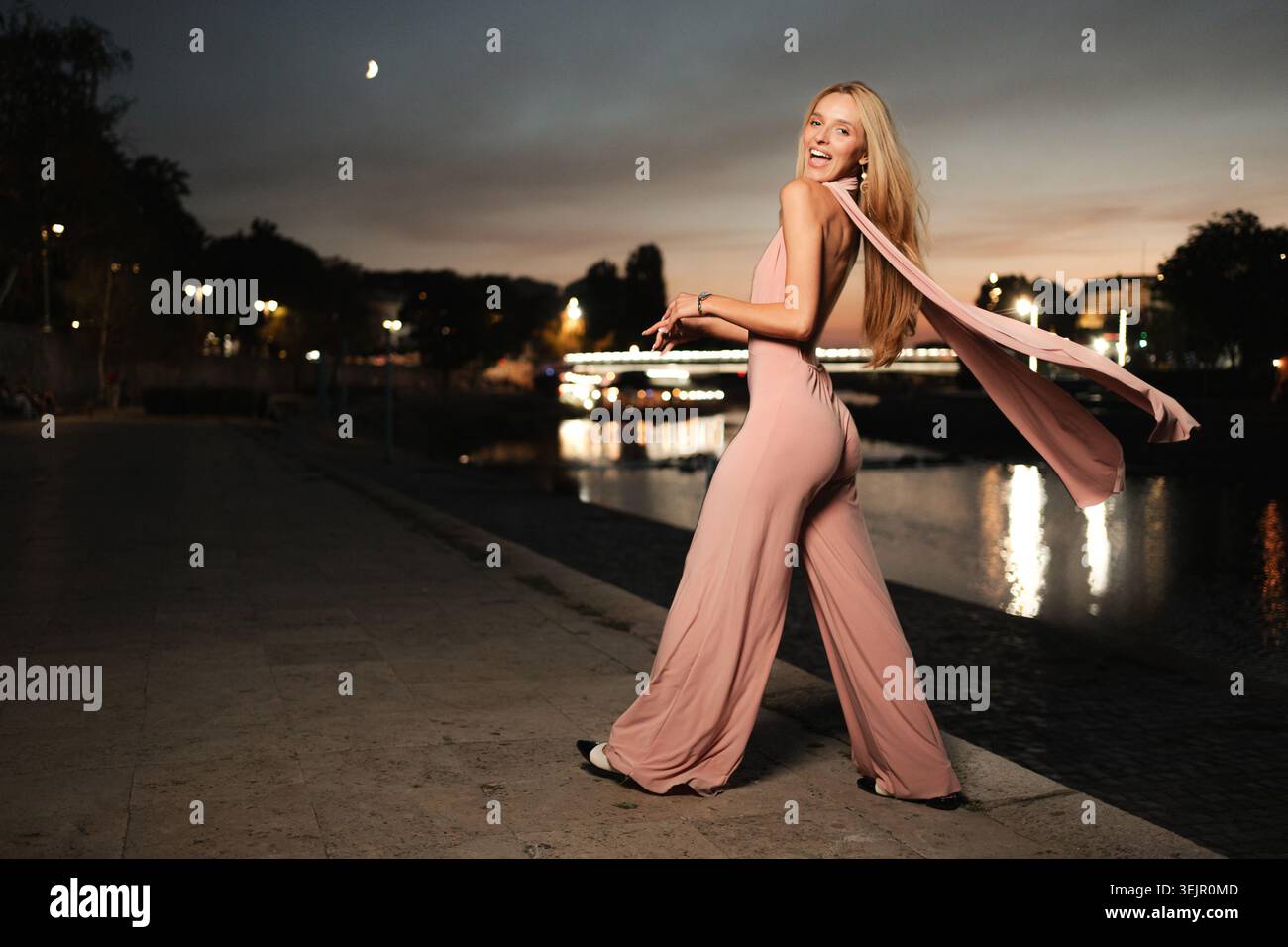 Anmutiger Abendspaziergang am Fluss in stilvollem Outfit Stockfoto