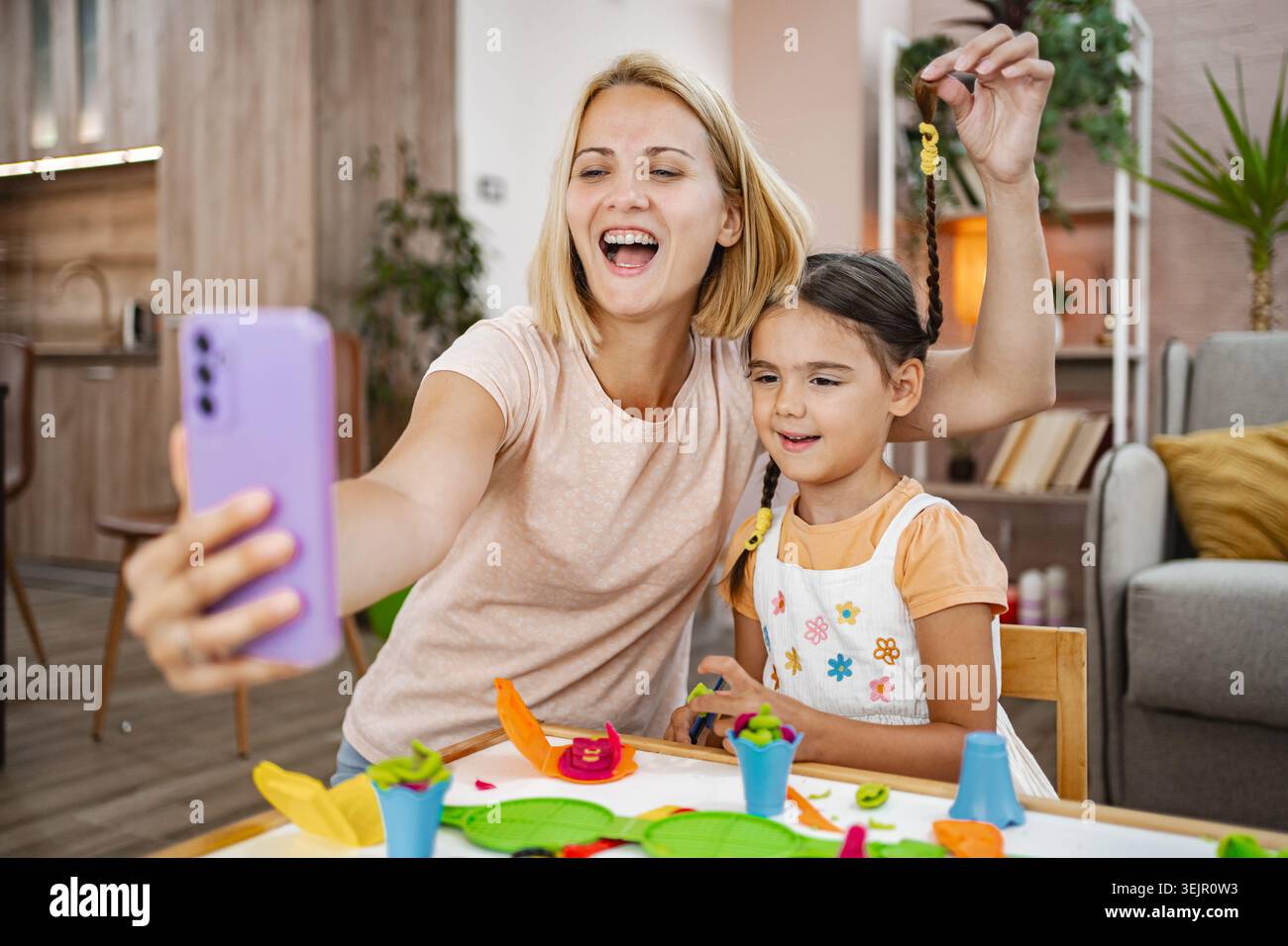 Mutter und Tochter genießen einen spielerischen Moment während sie ein Selfie machen Stockfoto