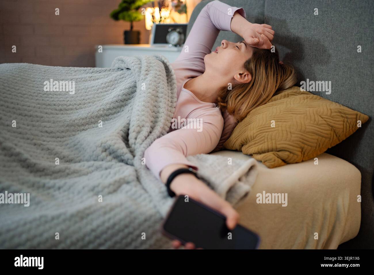 Frau mit Kopfschmerzen und Schlaflosigkeit im Schlafzimmer Stockfoto