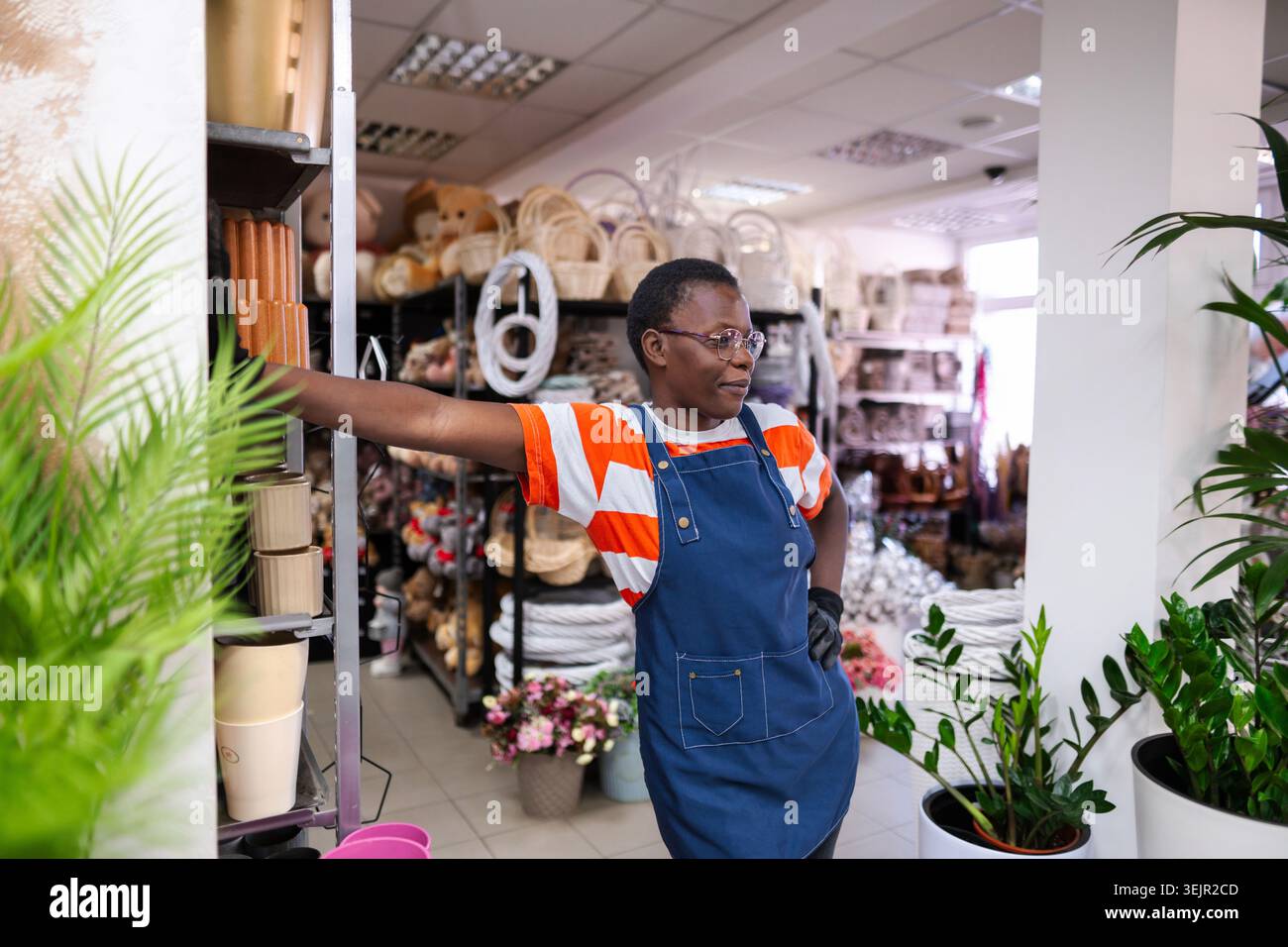 Selbstbewusste Floristin macht eine Pause in ihrem Blumenladen Stockfoto