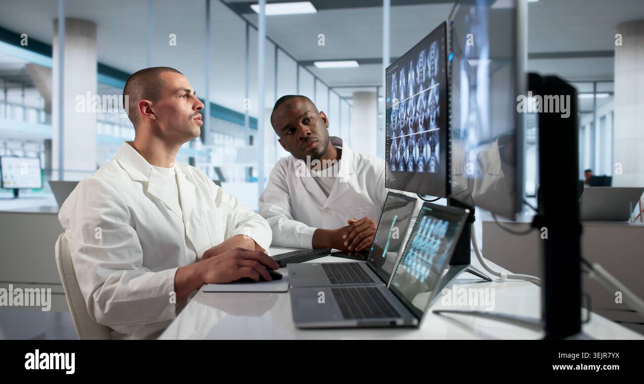 Zwei Ärzte überprüfen die Röntgen von Knie und Schulter auf dem Desktop zur Diagnose. Stockfoto