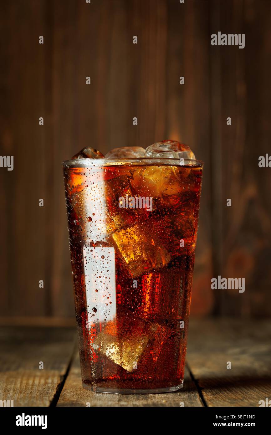 Cola mit zahlreichen Eiswürfeln und sprudelnden Blasen, Kondenswasser bildet sich auf dem Glas Stockfoto