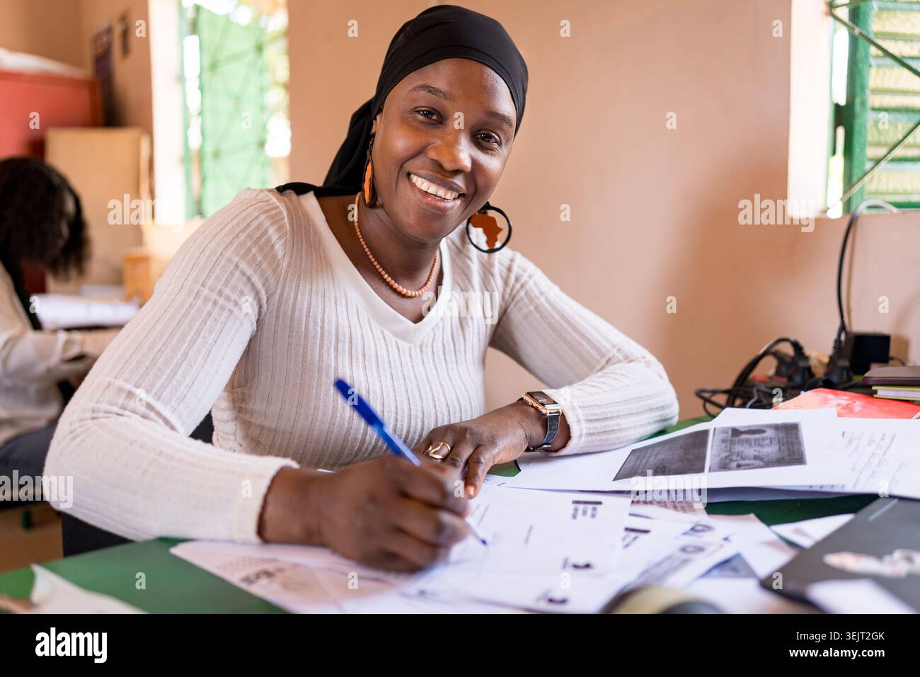 Porträt einer lächelnden jungen afrikanischen Geschäftsfrau, die am Schreibtisch sitzt und an einem Laptop arbeitet, Unternehmertum in afrika Stockfoto
