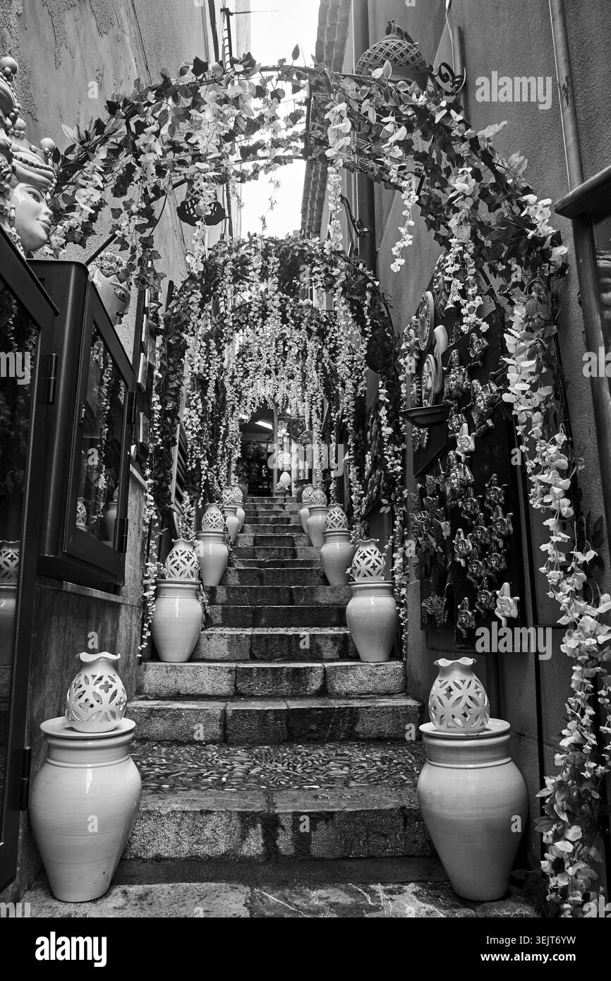 Dekorierte enge Straße mit Treppen in Taormina auf der Insel Sizilien, Italien, monochrome Stockfoto
