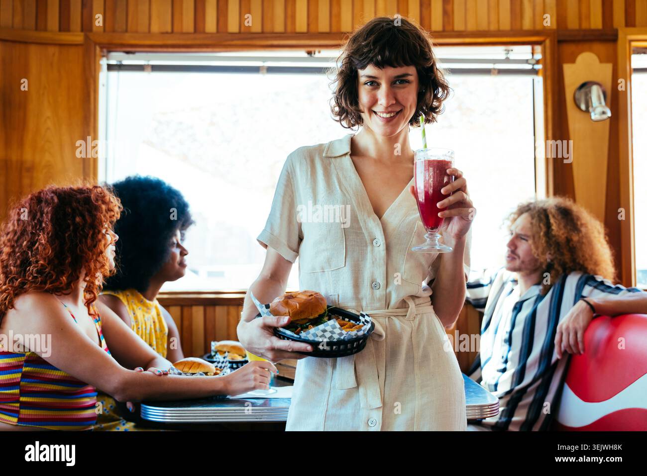 Multiethnische Gruppe junger glücklicher Freunde, die sich im Vintage Diner Burger House Restaurant verbünden - junge Leute genießen Essen und Trinken, verbinden sich im Restaurant Stockfoto